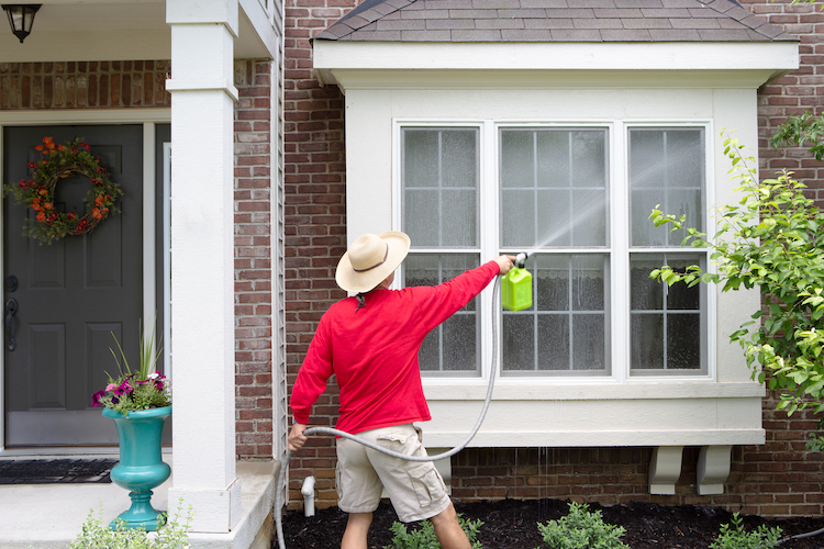 Homeowner Cleaning Windows After Winter - K-Guard Heartland