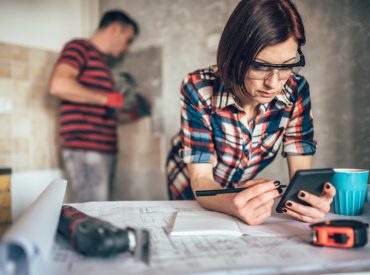 Woman on Cell Phone and Man in Background Removing Tile Work from Wall - K-Guard Heartland