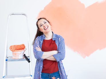 Woman painting the walls of new home. Renovation, repair and redecoration.